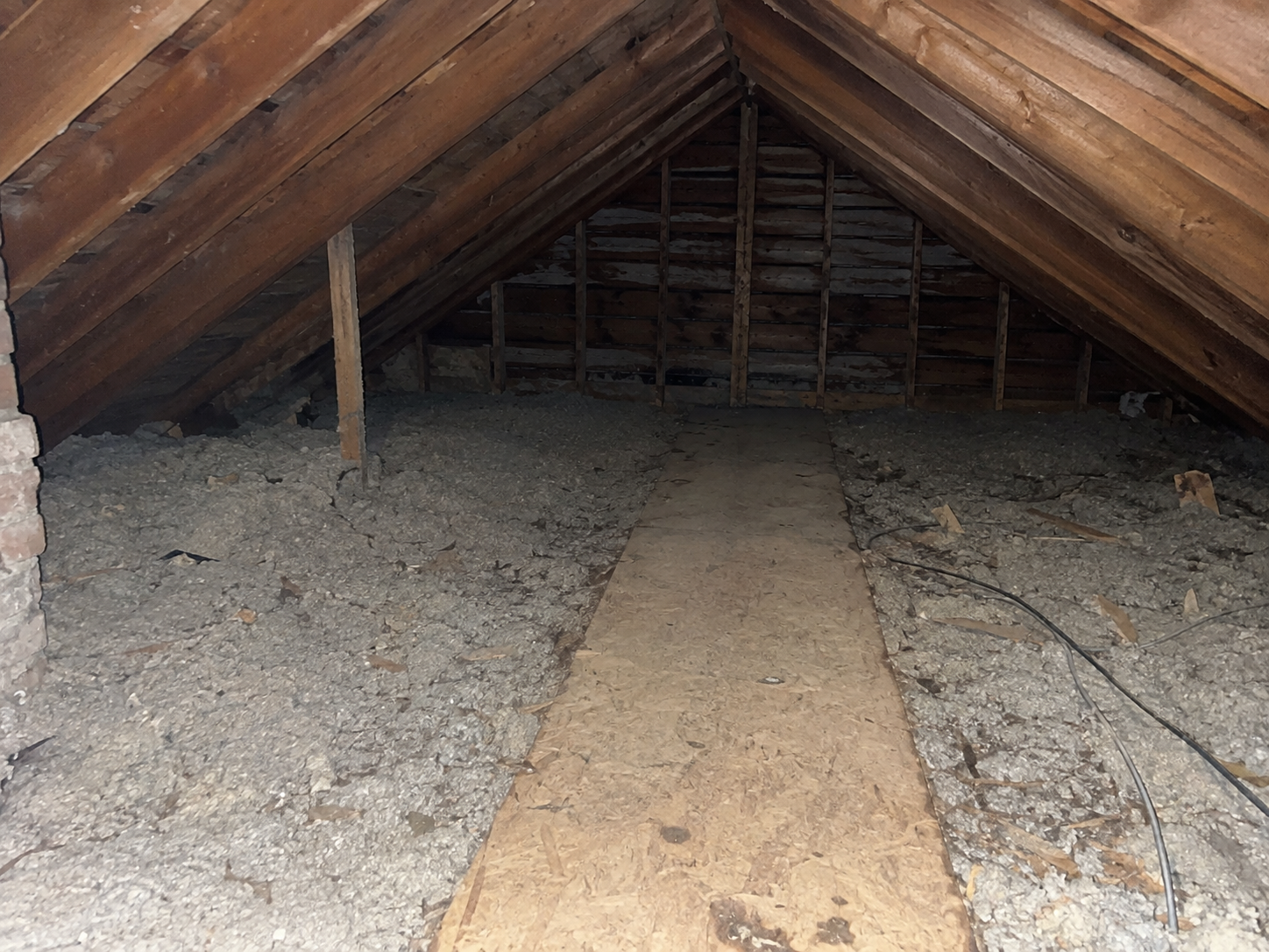 Old and deteriorated attic insulation inside a Clarksville, Maryland attic before professional insulation removal