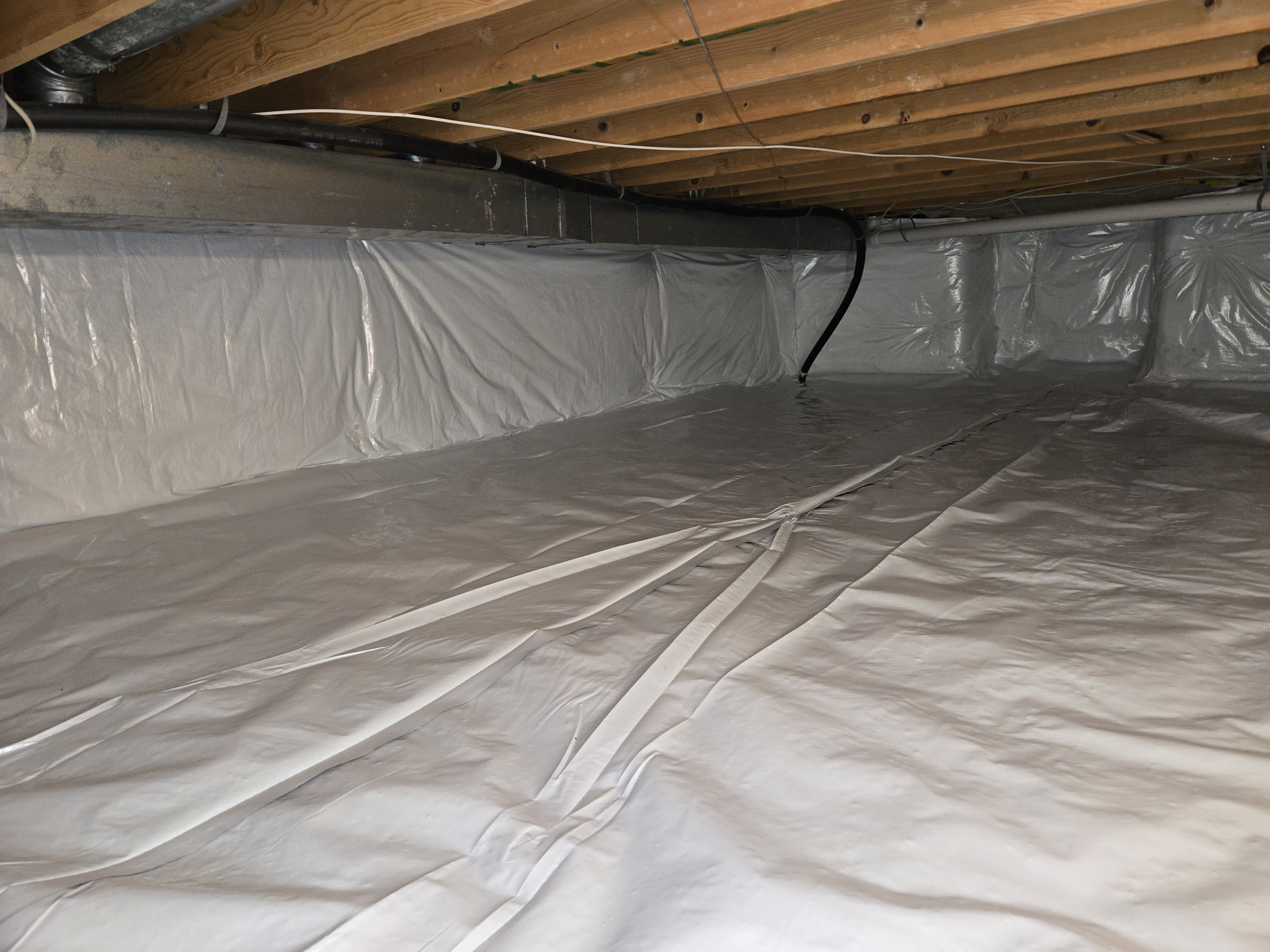 Completed crawl space encapsulation with a white reinforced liner on the floor and walls, installed by Xanvria in Maryland
